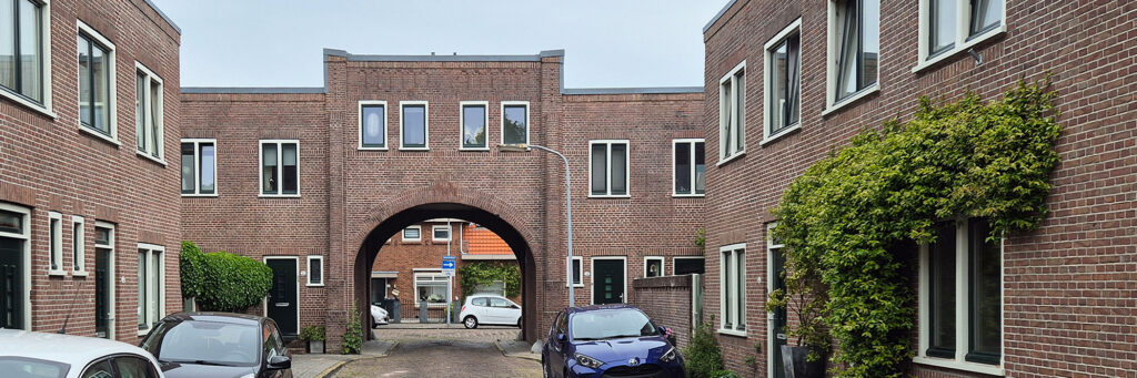 doorkijk foto waar je een straat verlaat door een boog die woningen verbind