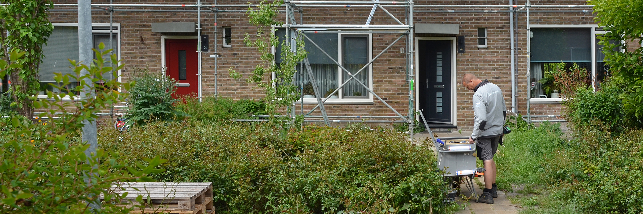 woning die in de stijger staat. in de tuin staat iemand met kluskleren aan
