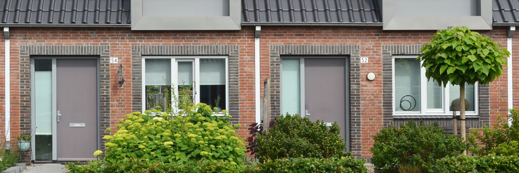 woningen met grijze deuren en in de tuin heel veel groen