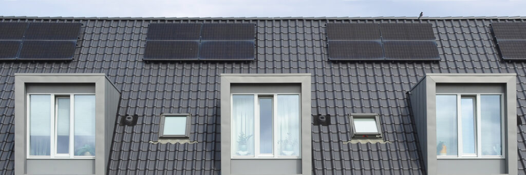 Woningen waarbij je de dakkapellen ziet. op het dak liggen zonnepanelen