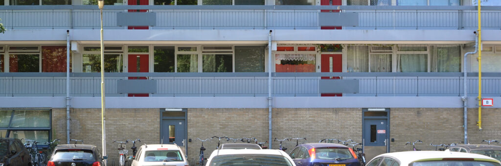 flatgebouw met voordeuren aan de buitenkant de kleuren van de wandelgang is blauw aan de buitenkant. de deuren van de woningen zijn rood