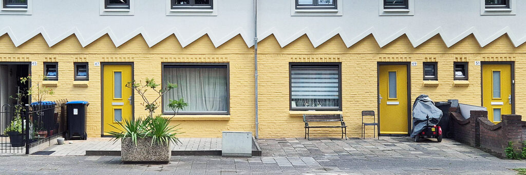 woningen met een gele onderkant, er zit een rafelrand die de onderkant en bovenkant onderscheid van elkaar. de bovenkant is wit