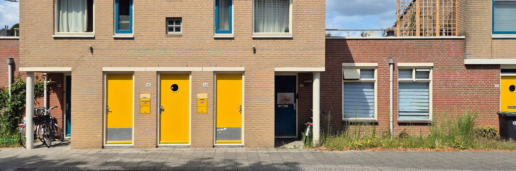 entree van drie woningen met gele deuren aan de stoep
