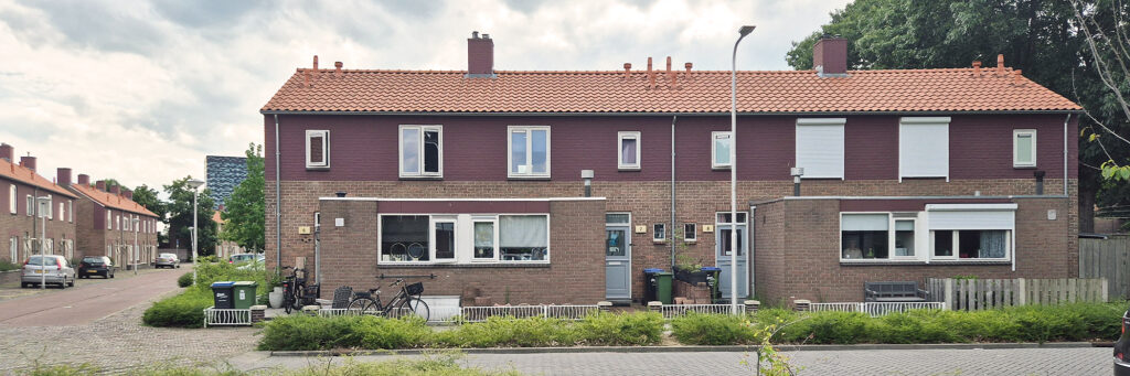 woningen met paarsige bovenverdieping. de woningen liggen aan straat gescheiden door een groen strookje