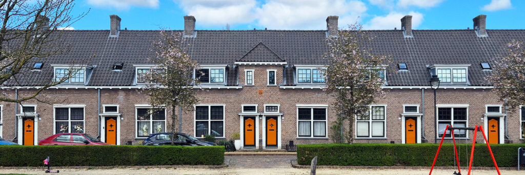 wat oudere woningen met witte kozijnen. ervoor zit een speeltuin